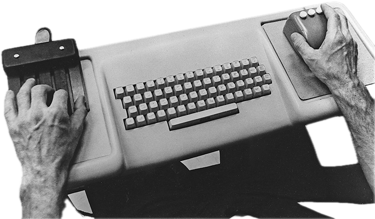 The NLS console: a keyboard between a chord keyset and a three-button mouse, one hand on each.